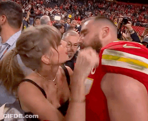 Woman Kissing Man In Red Jersey With Letter O GIF