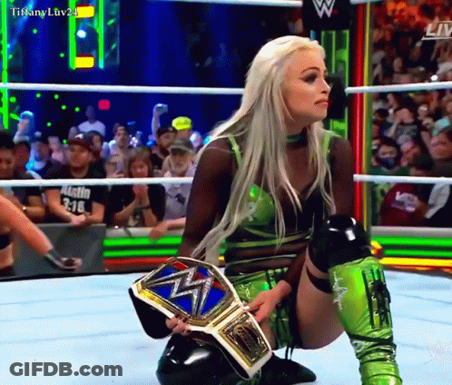Woman Kneeling In Wrestling Ring Holding Tiffany Luv24 Belt GIF