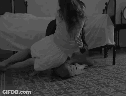 Woman Kneeling On Man's Lap In Bedroom GIF