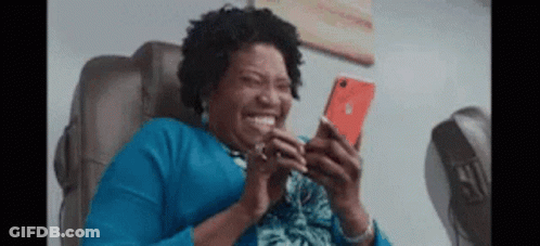 Woman Laughing At Phone In Chair GIF