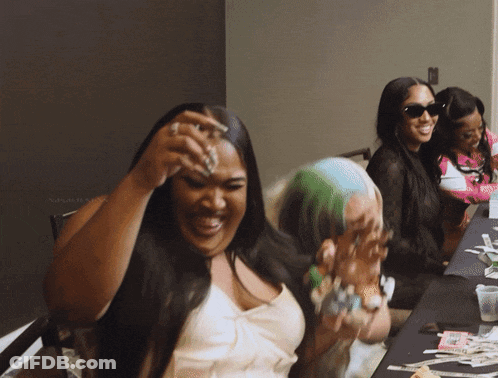 Woman Laughing At Table With Money GIF