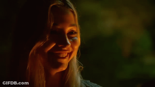 Woman Laughing Holding Beer In Dark Room GIF
