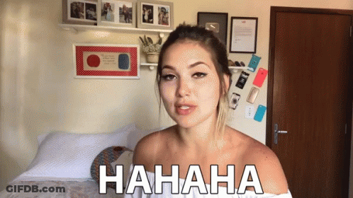 Woman Laughing In Bedroom With Hahaha On Wall GIF