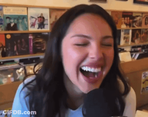 Woman Laughing Into Microphone In Store GIF