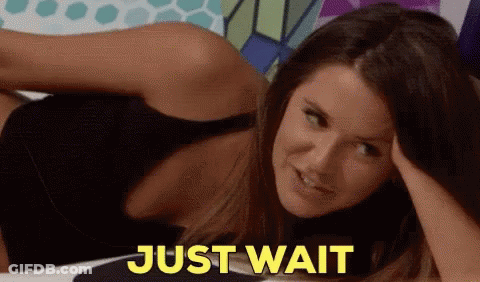 Woman Laying Down Saying Just Wait In Yellow GIF