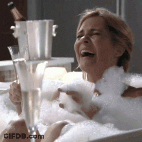 Woman Laying In Bathtub Holding Wine GIF