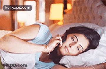 Woman Laying In Bed Eyes Closed Talking On Phone GIF
