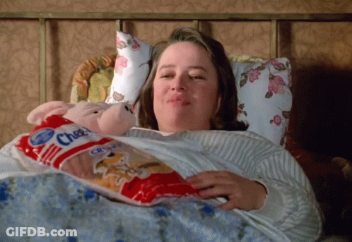 Woman Laying In Bed Holding Cheez Crisps GIF