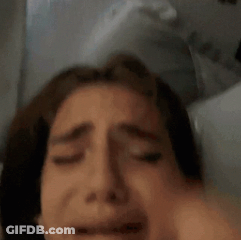 Woman Laying In Bed With Hand On Head GIF