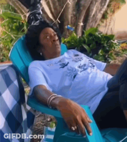 Woman Laying In Blue Chair In Garden GIF
