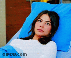 Woman Laying In Hospital Bed With Blue Pillows GIF