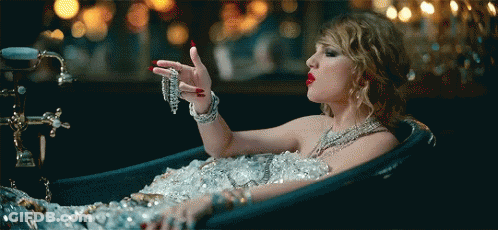 Woman Laying In Ice-Filled Bathtub Holding Necklace GIF