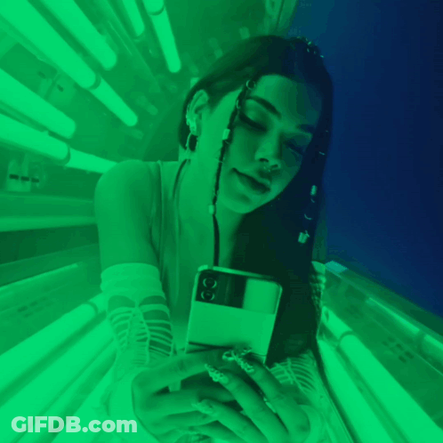 Woman Laying In Tanning Bed With Green Lights GIF