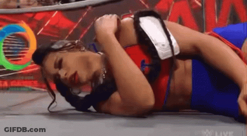 Woman Laying In Wrestling Ring Holding Arm GIF
