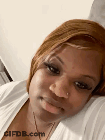 Woman Laying On Bed Head On Pillow Looking At Camera GIF