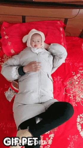 Woman Laying On Bed Holding Baby GIF.PET GIF