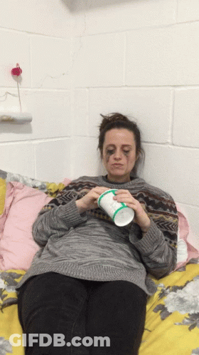 Woman Laying On Bed Holding Iced Tea Cup GIF