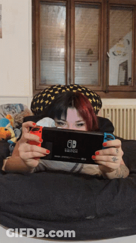 Woman Laying On Bed Playing Nintendo Switch GIF