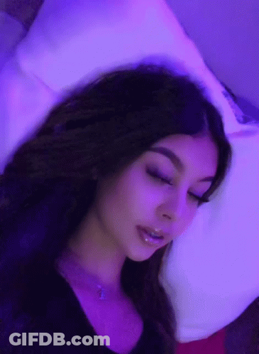 Woman Laying On Bed With Purple Lights GIF