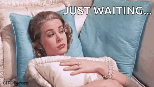 Woman Laying On Bed With Ring Saying Just Waiting GIF