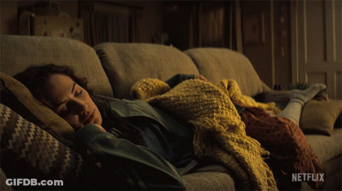 Woman Laying On Couch With Blanket And Netflix Logo GIF