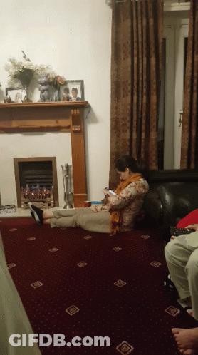 Woman Laying On Floor Looking At Phone GIF