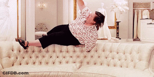 Woman Laying On White Couch With Arms Up GIF