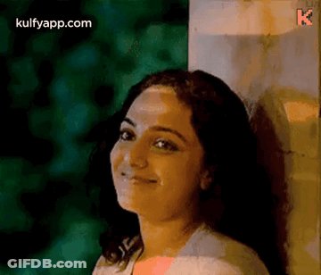 Woman Leaning Against Wall Smiling GIF