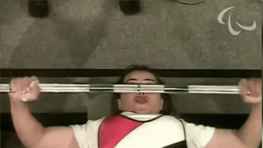 Woman Lifts Barbell Row While Laying Down GIF