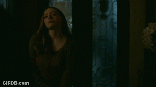 Woman Looking At Camera In Dark Room GIF