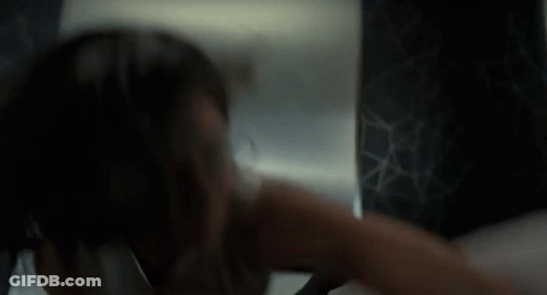 Woman Looking At Herself In Mirror In Dark Room GIF