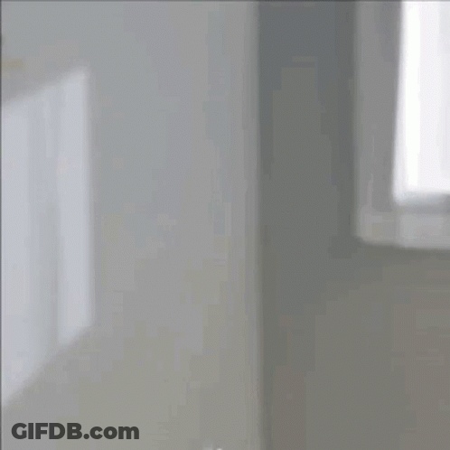 Woman Looking At Herself In Mirror With Bun GIF