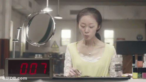 Woman Looking At Mirror With 007 Clock GIF