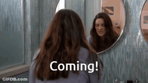 Woman Looking In Bathroom Mirror Saying Coming GIF