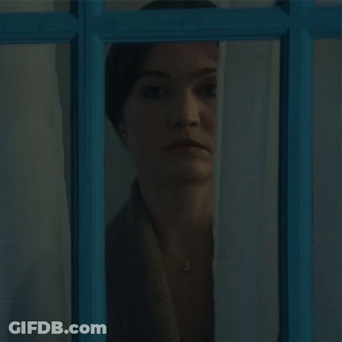 Woman Looking Out Blue Window GIF