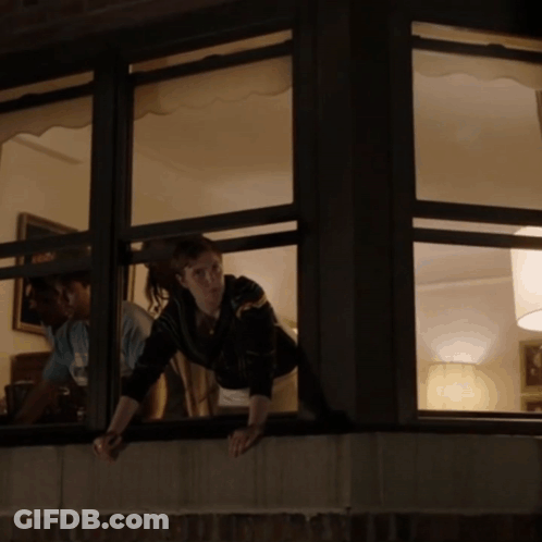 Woman Looking Out Window With Man Behind GIF