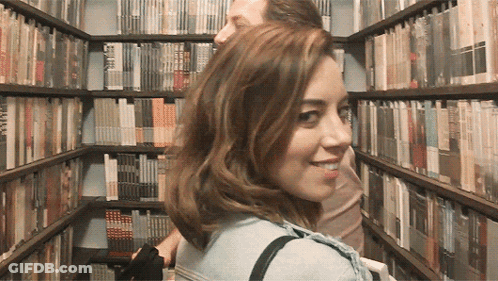 Woman Looking Over Shoulder In Library GIF