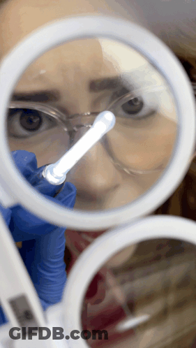 Woman Looking Through Magnifying Glass At Light GIF