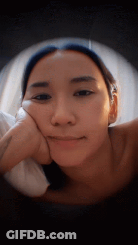 Woman Lying Down With Hand On Face GIF