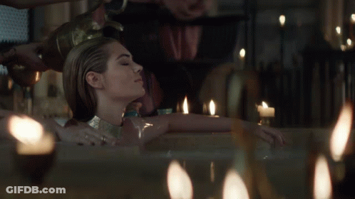 Woman Lying In Bathtub With Candles GIF