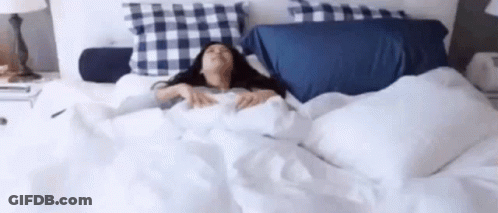 Woman Lying In Bed With Blue Plaid Pillows GIF