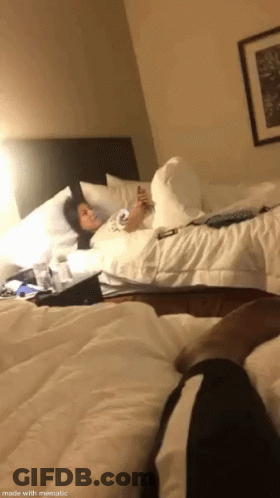 Woman Lying On Bed Looking At Cell Phone GIF