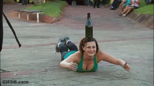 Woman Lying On Ground With Bottle On Head GIF