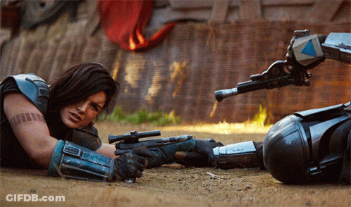Woman Lying On Ground With Gun GIF