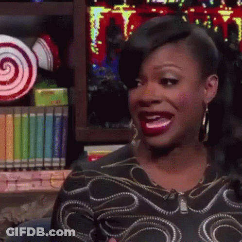 Woman Making Funny Face At Bookshelf With Lollipops GIF