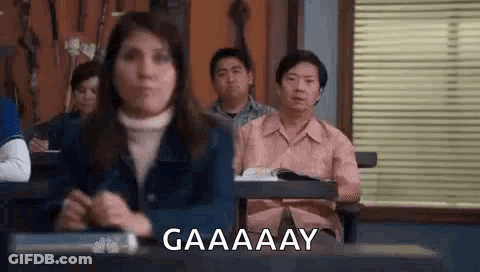 Woman Making Funny Face At Desk In Classroom GIF