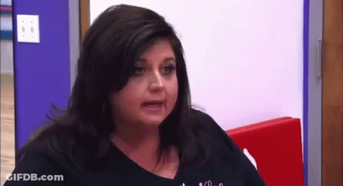 Woman Making Funny Face At Red Wall GIF