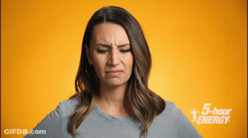 Woman Making Funny Face In Front Of 5 Hour Energy Sign GIF