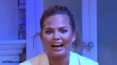 Woman Making Funny Face In Front Of Blue Wall GIF