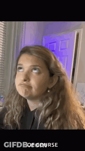 Woman Making Funny Face In Front Of Purple Door And Window GIF